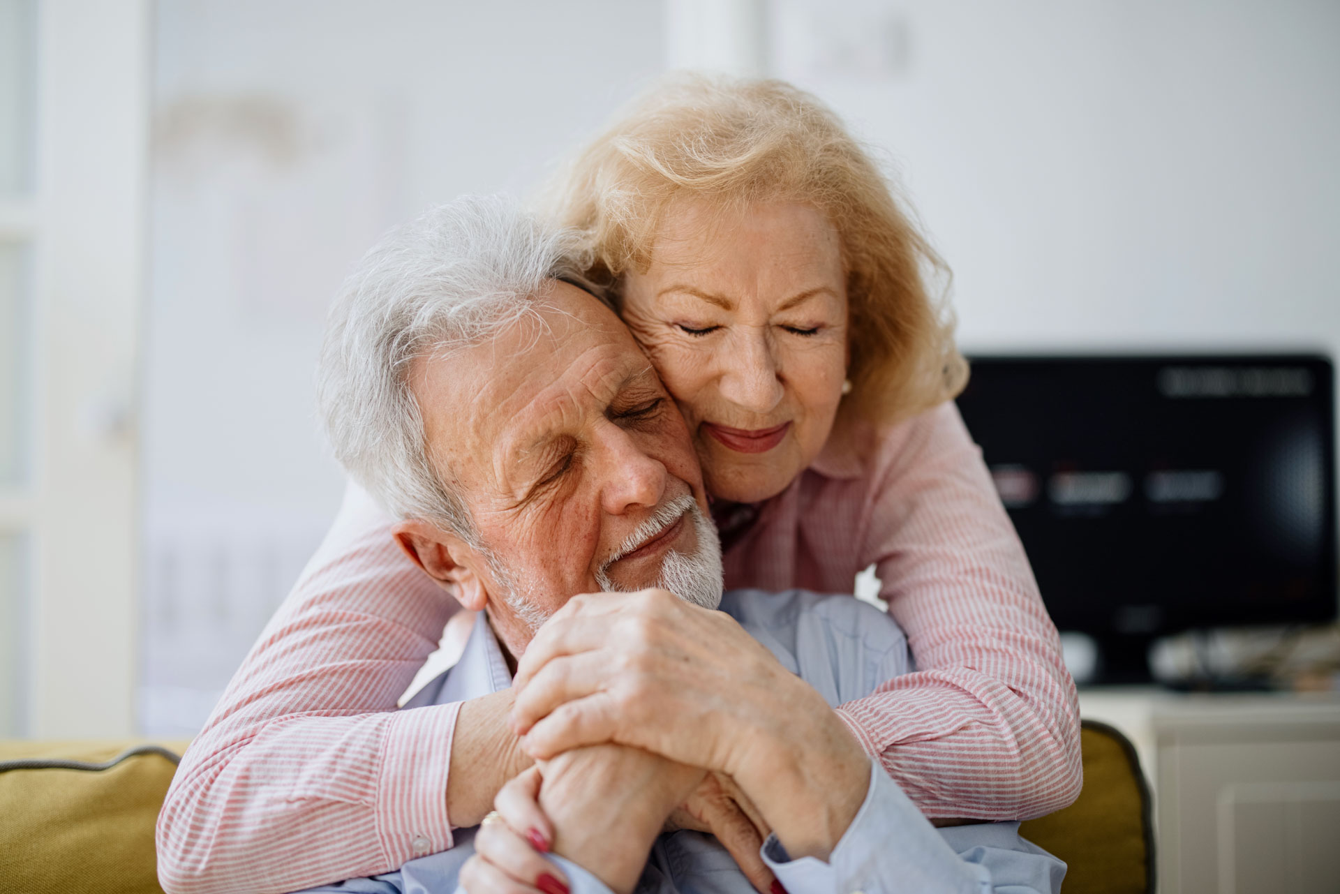 Portrait eines glücklich älteren Paares, das sich umarmt.